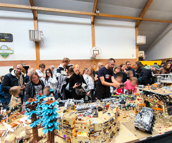 Public découvrant le diorama LEGO Eibon à l’exposition Yvré en Briques 2026, visages des enfants floutés
